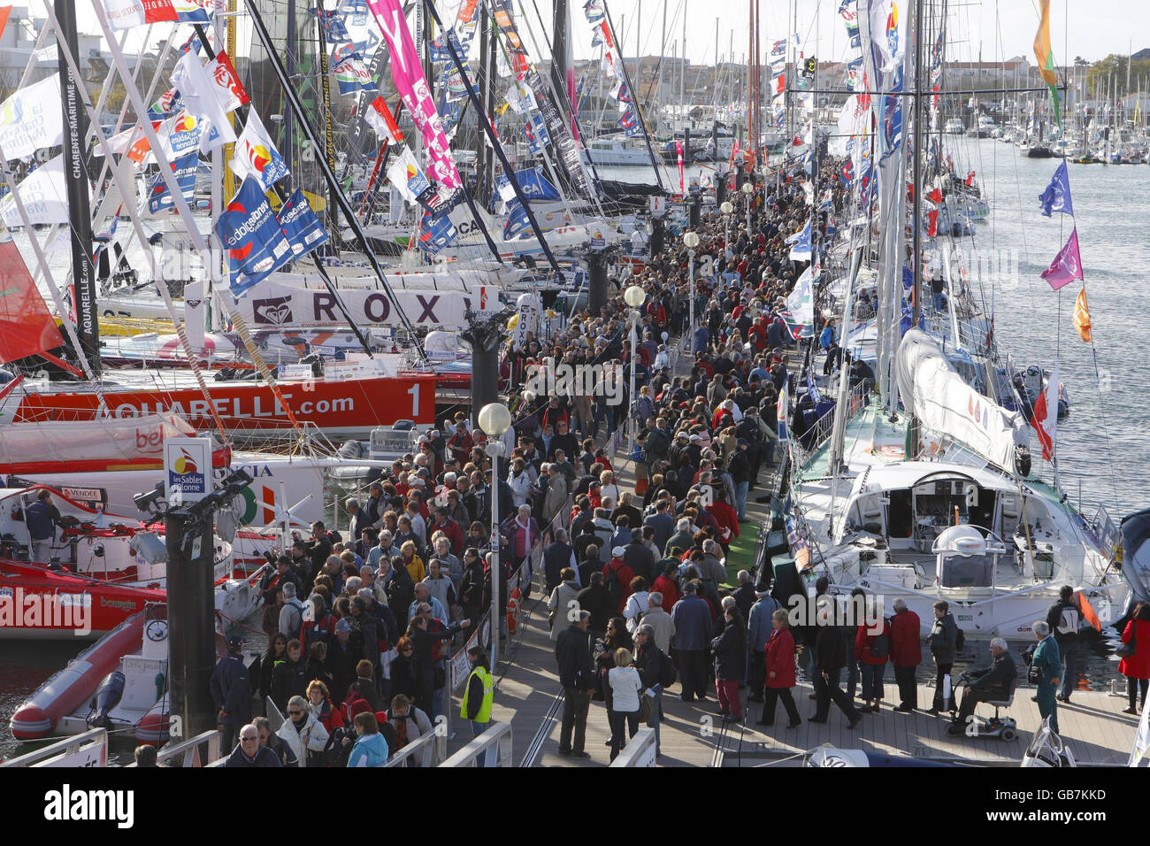 Migliaia di visitatori guardano agli ultimi yacht da corsa high-tech di Les Sables d'Olonne, in Francia, prima della gara Vendee Globe che inizia domenica. Foto Stock
