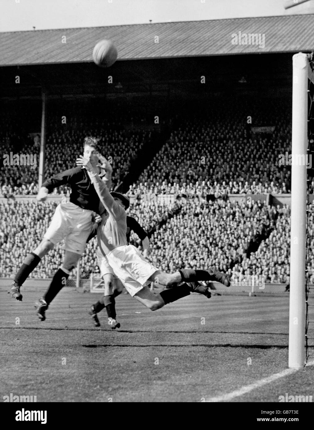 Il portiere scozzese Jimmy Cowan (r) salta per salvare come suo il compagno di squadra guida la palla verso l'esterno per un angolo Foto Stock