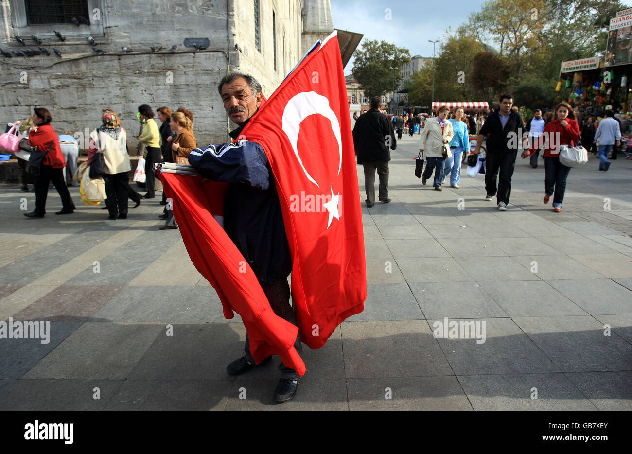 Travel stock - Istanbul - Turchia. Un uomo vende bandiere turche fuori dalla Nuova Moschea Foto Stock