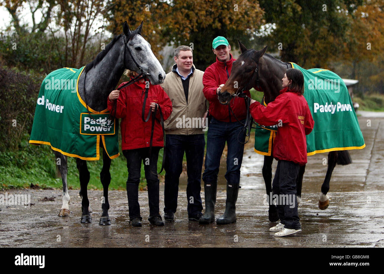 Il Trainer David Pipe (centro a destra) si trova tra piraya (a sinistra) e Vodka Blue (a destra) con il bookmaker Paddy Power presso il suo cantiere a David Pipe Stables, Pond House, Somerset. Foto Stock