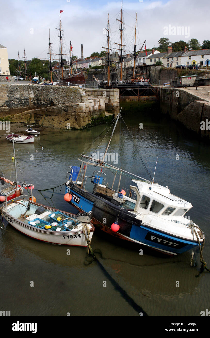 Due barche da pesca si trovano nelle brughiere del porto di Charlestown, a bassa marea, Cornovaglia Foto Stock