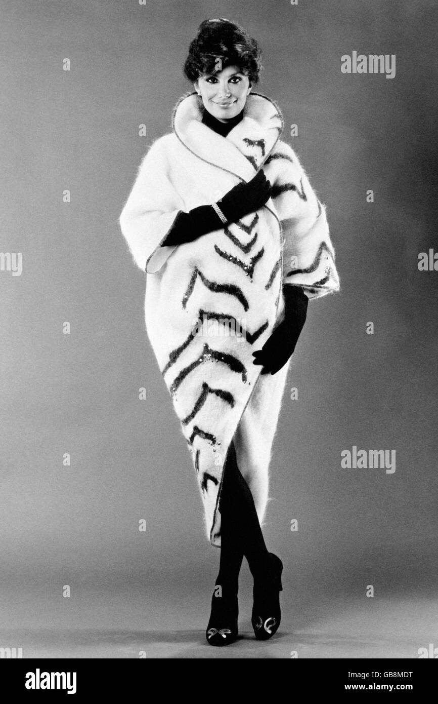 Il mohair bianco neve è prodotto da Samuel Tweed, di Huddersfield, West Yorkshire, e scelto dal designer Bill Gibb per questo wrap-coat dipinto a mano e brillantato. Le strisce della tigre sono in nero e marrone e selezionate in bronzo scintillante per adattarsi al bordo. Il modello è Sashy Bayer. Foto Stock