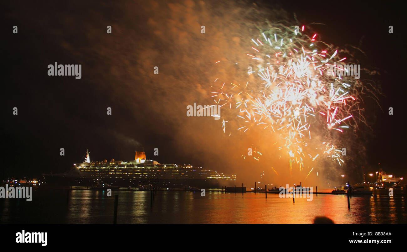 I fuochi d'artificio esplodono nel cielo mentre la nave Cunard da 70,000 tonnellate, la QE2, lascia le banchine di Southampton per l'ultima volta. Foto Stock