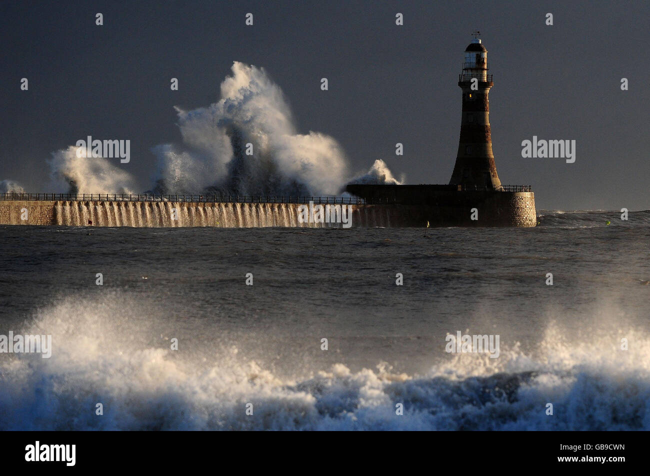 Le onde della tempesta colpiscono il faro di Seaham a Sunderland mentre un fronte meteorologico artico colpisce la costa orientale. Foto Stock