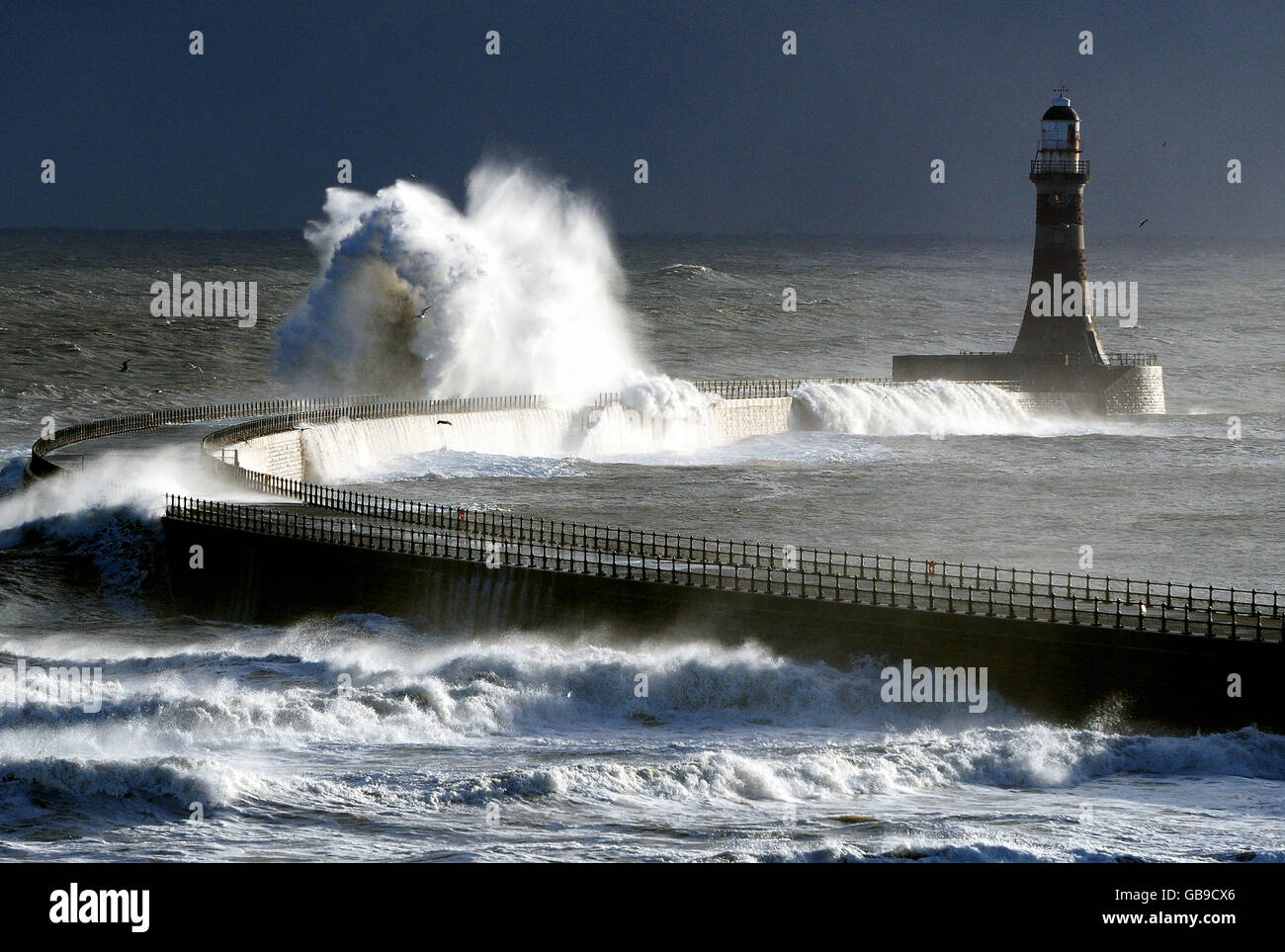 Le onde della tempesta colpiscono il faro di Seaham a Sunderland mentre un fronte meteorologico artico colpisce la costa orientale. Foto Stock