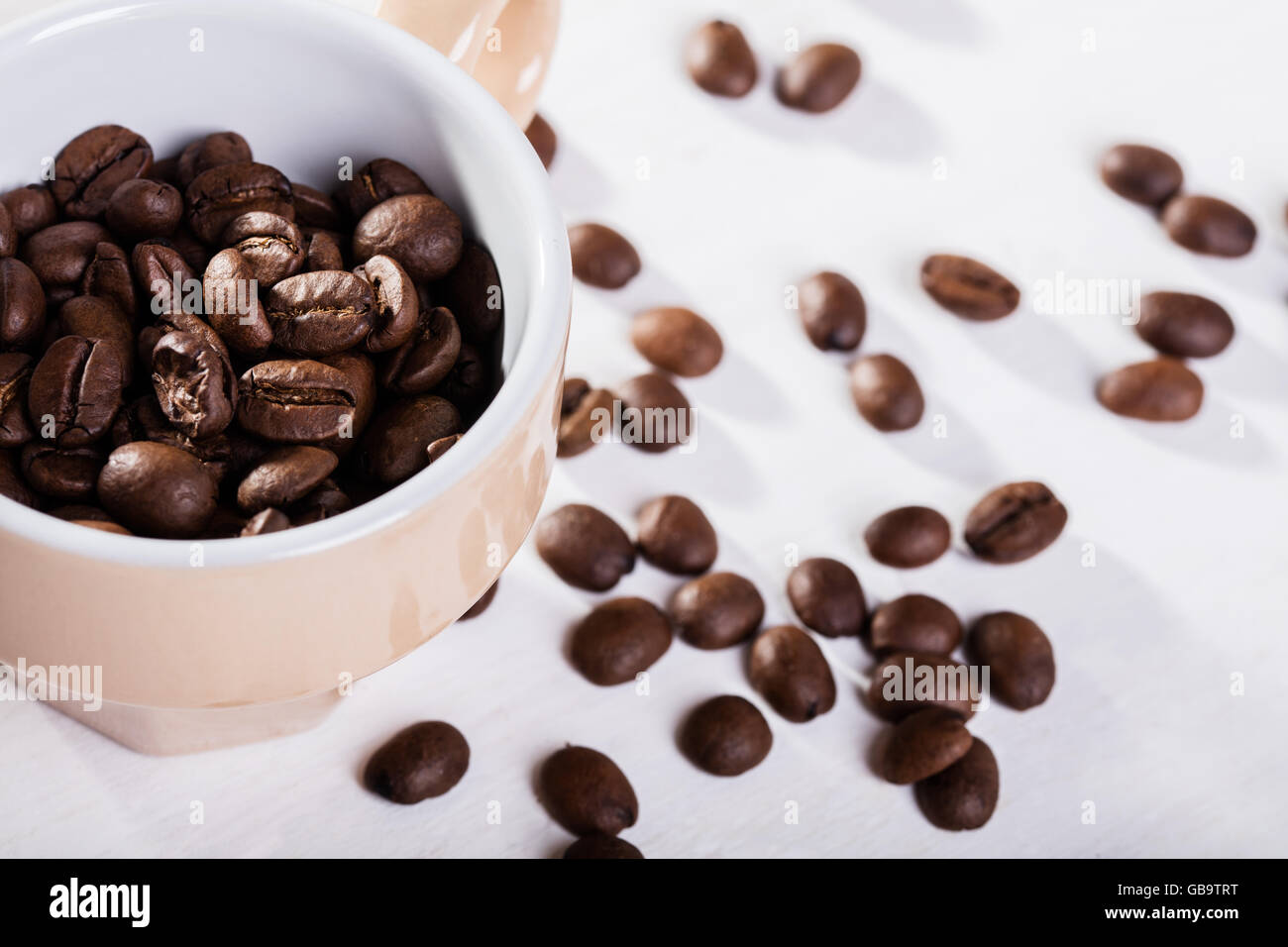 Semi di caffè in tazza di colore beige Foto Stock