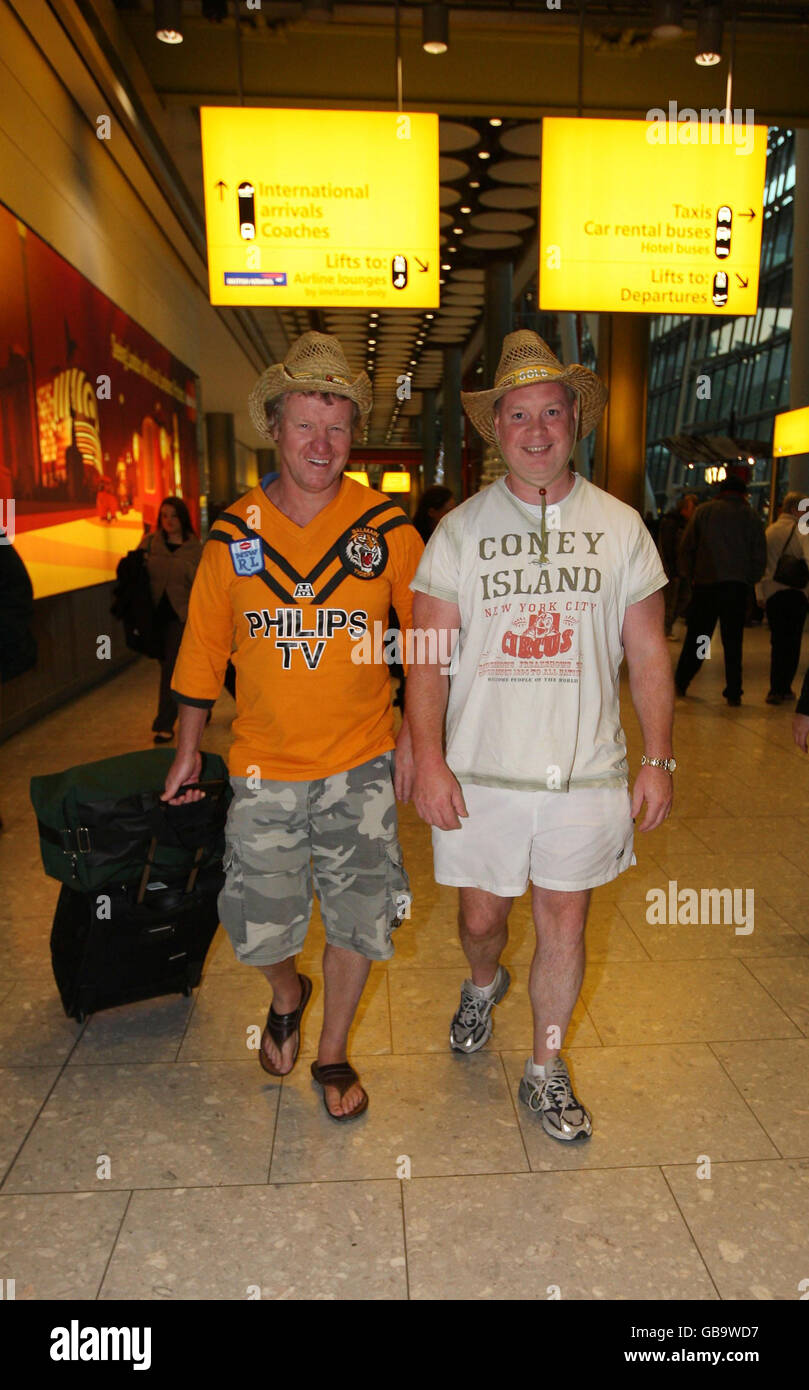 I passeggeri Graham Shaw (L) e David Bottomley da Hull arrivano sul volo British Airways da Phuket dopo essere rimasti bloccati in Thailandia quando le proteste anti-governative hanno chiuso il principale aeroporto internazionale del paese. Foto Stock