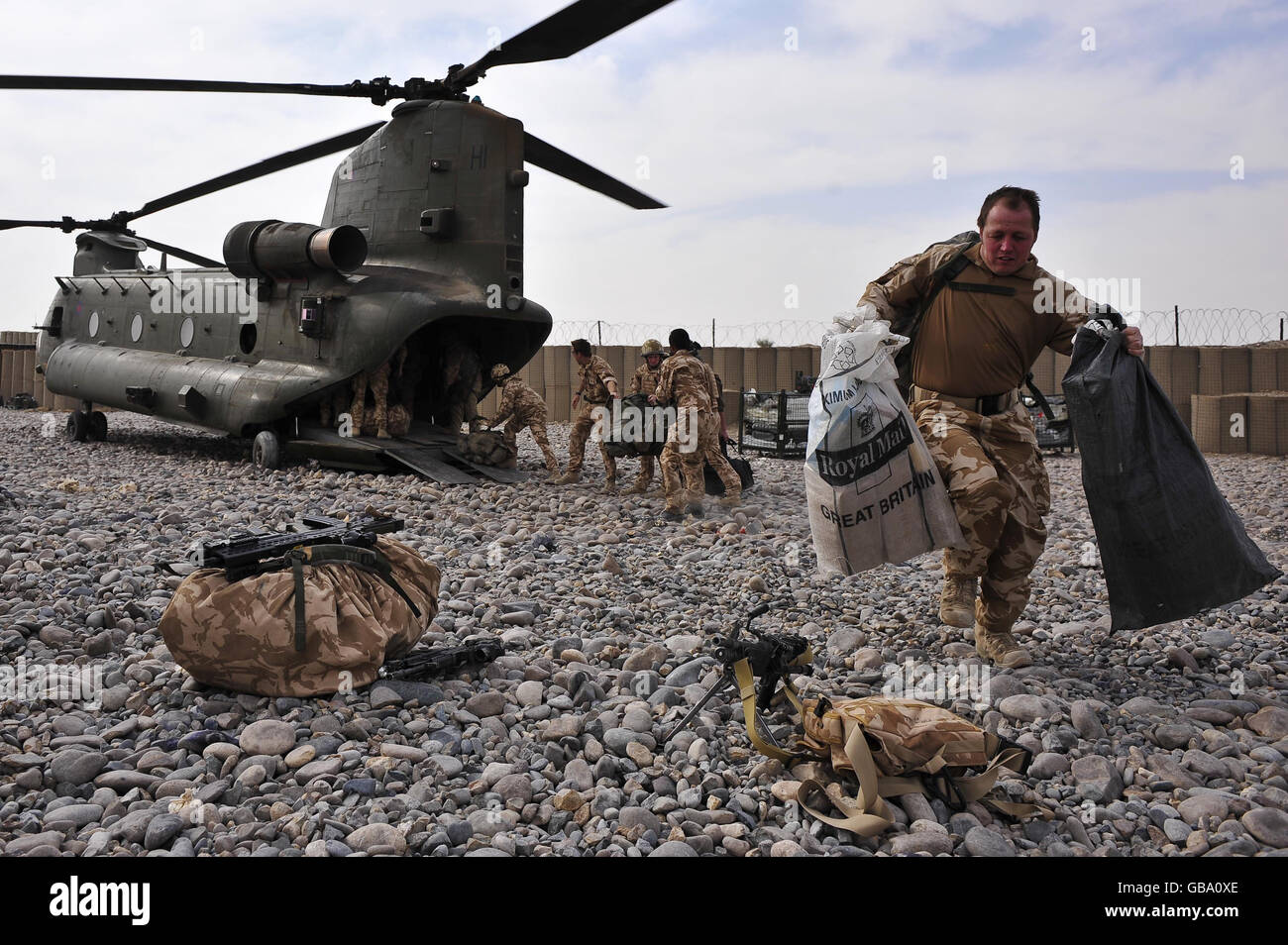 Un soldato consegna la posta in sacche Royal Mail da un elicottero Chinook che partì dal Bastione Camp ai soldati della base operativa Forward (FOB) Dehli, distretto di Garmsir, provincia di Helmand, Afghanistan. Foto Stock