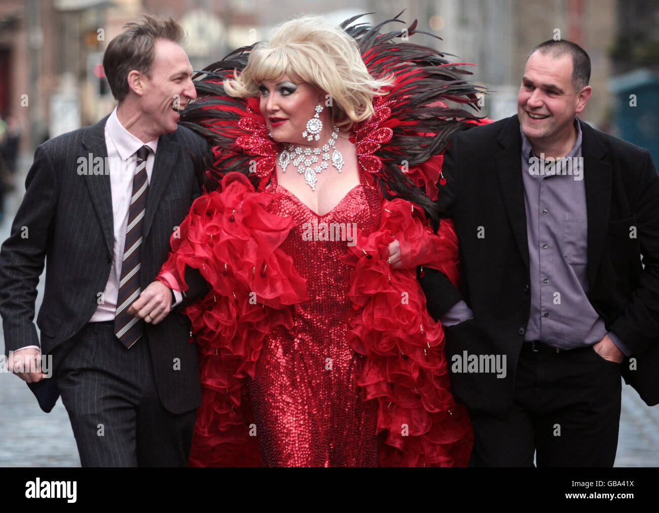 Il Segretario di Stato per la Scozia Jim Murphy (a sinistra) con Amanda Monroe di Drags Aloud e Tim Hawkins del Festival delle frange di Edimburgo cammina fino al Royal Mile di Edimburgo per evidenziare l'azione del governo britannico per mantenere lo status di festival senza permesso Foto Stock