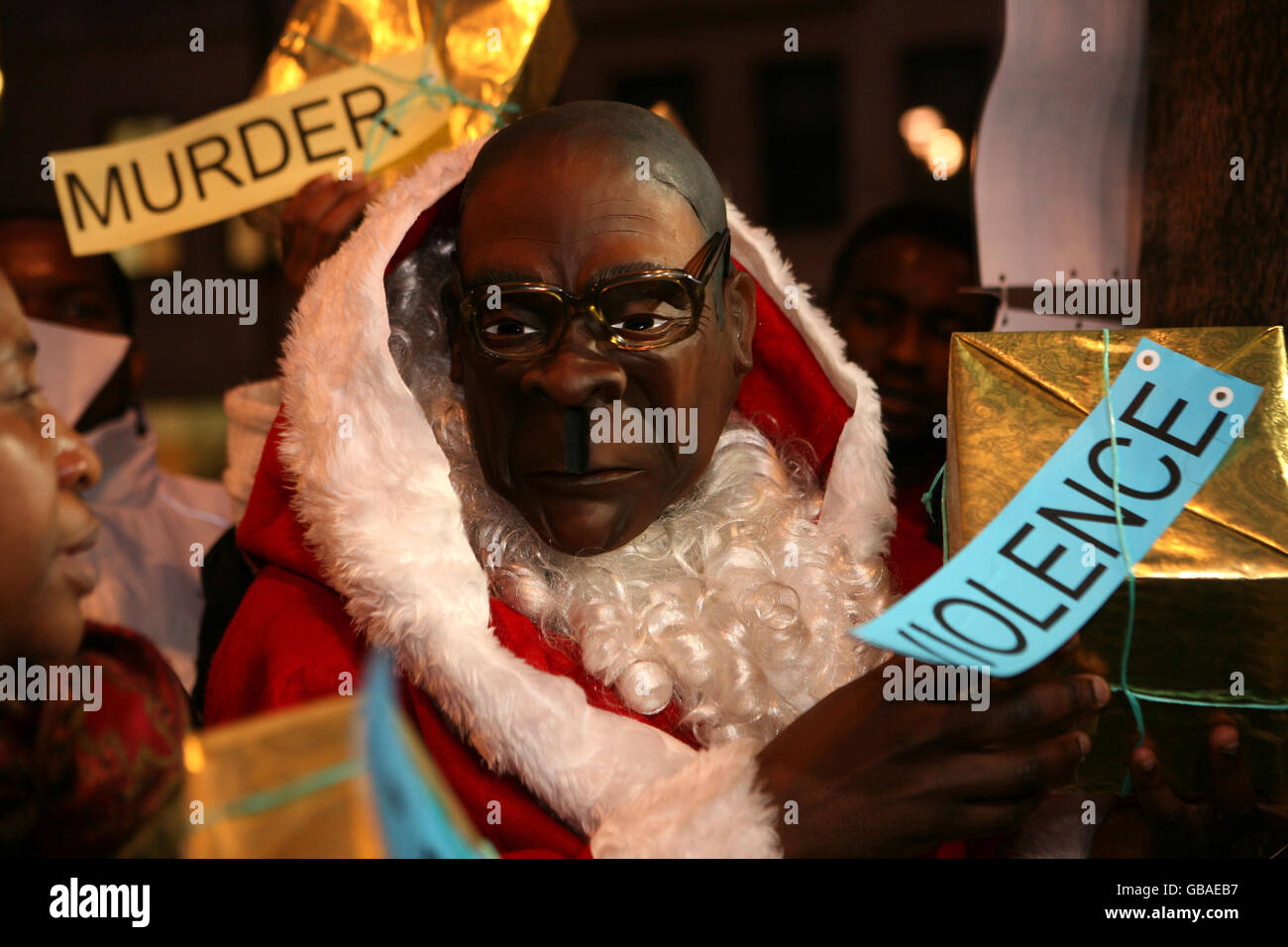 Un manifestante vestito con una tuta di Babbo Natale e che indossa una maschera Robert Mugabe fuori dall'ambasciata dello Zimbabwe a Londra, dove i manifestanti hanno chiesto un'azione per cacciare Mugabe dal potere nel paese, che si trova nella morsa di una grave epidemia di colera e vicino al collasso economico. Foto Stock