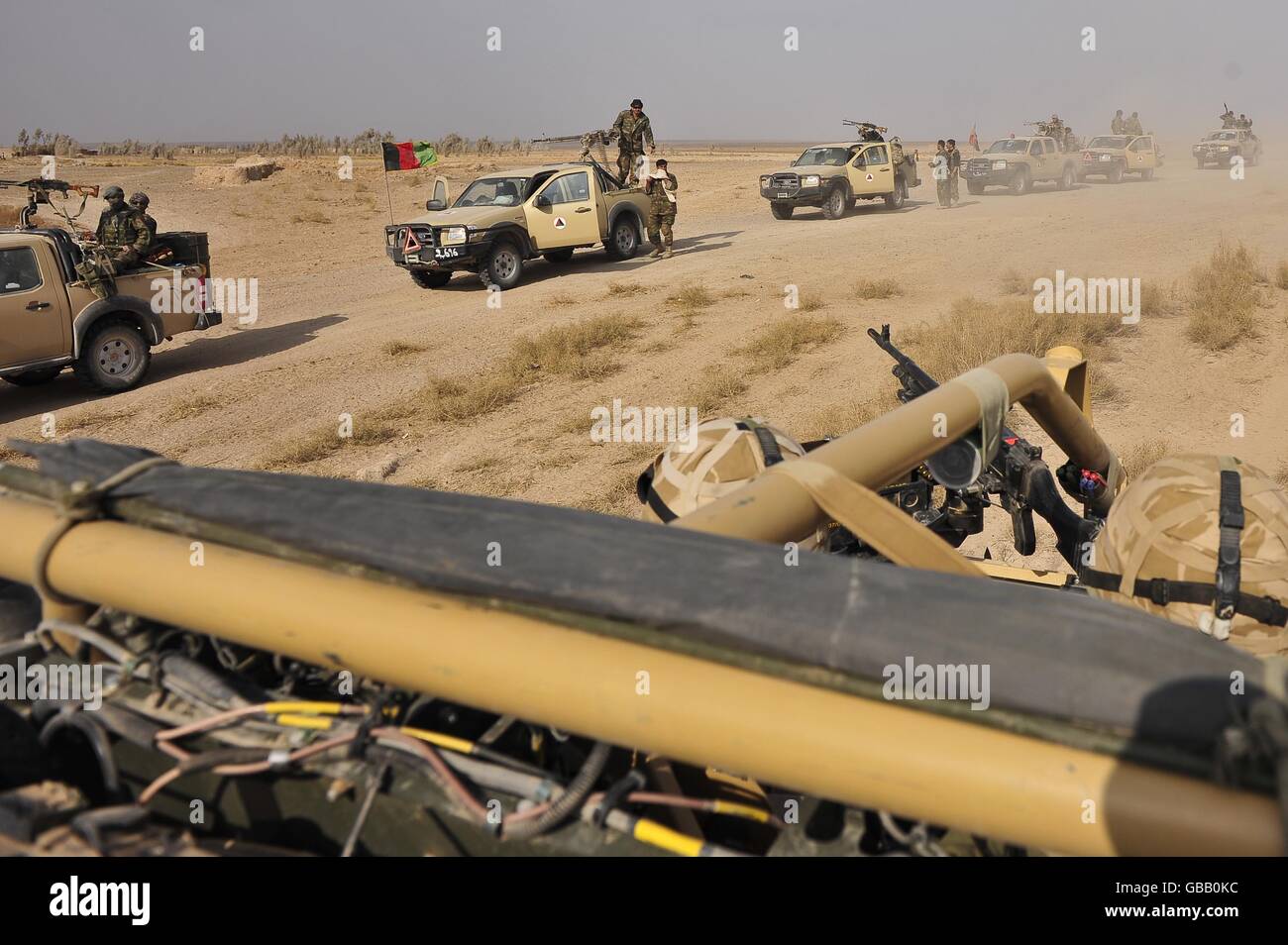 Il primo le Guardie del Dragoon delle Regine passano un convoglio dell'Esercito Nazionale Afgano poco dopo aver lasciato il Centro Distrettuale Garmsir dopo aver lasciato la base operativa Forward (FOB) Dehli nella provincia di Helmand, in Afghanistan per il deserto orientale. Foto Stock