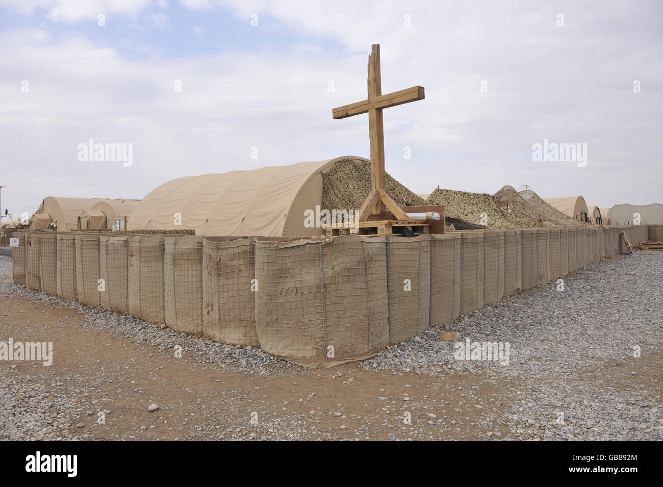 Una tipica barriera HESCO, fatta di semplice insaccatura in una gabbia di filo pieno di macerie, mattoni o pietre, che circonda la chiesa tenda a Bastione Camp, provincia Helmand, Afghanistan. Foto Stock