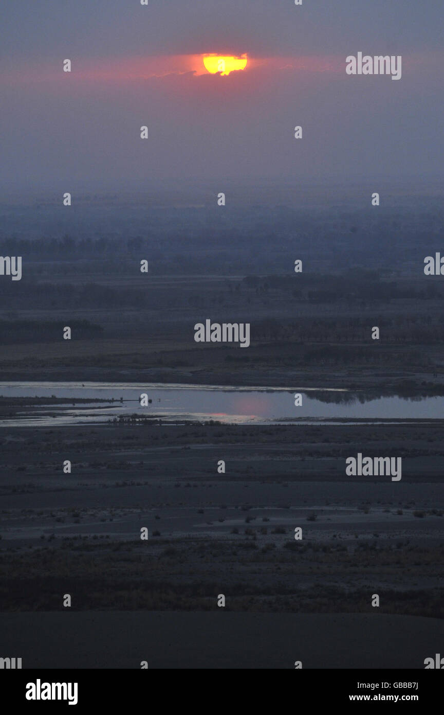 Il sole tramonta nei pressi di un'area di combattimento tra i talebani e l'esercito nazionale afgano nella regione di Nawa nella provincia di Helmand. Foto Stock