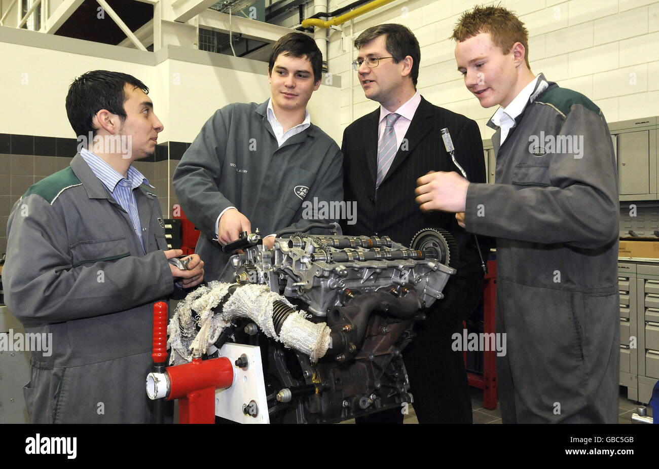 (Da sinistra a destra) gli apprendisti Jason Dalmas, Andrew Lowe e Ashley Colvin parlano con David Smith (seconda a destra), Chief Executive di Jaguar Land Rover, alla nuova accademia di formazione a basso consumo energetico di Jaguar Land Rover a Warwick. Foto Stock