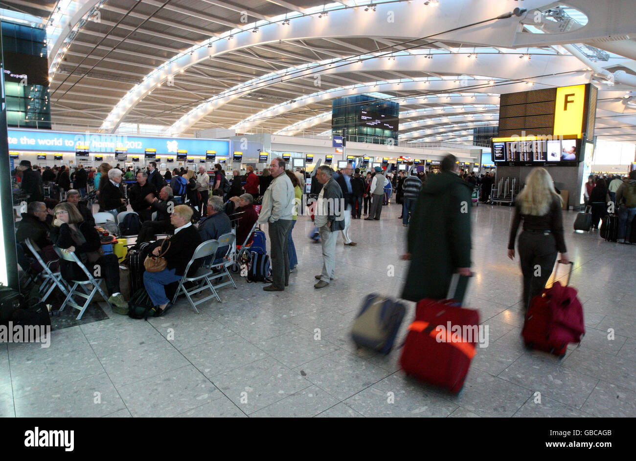 I passeggeri in coda al terminal 5 dell'aeroporto di Heathrow dopo che ieri sono stati annullati quasi 800 voli all'aeroporto a causa di una forte nevicata e altri sono stati soggetti a lunghi ritardi. Foto Stock