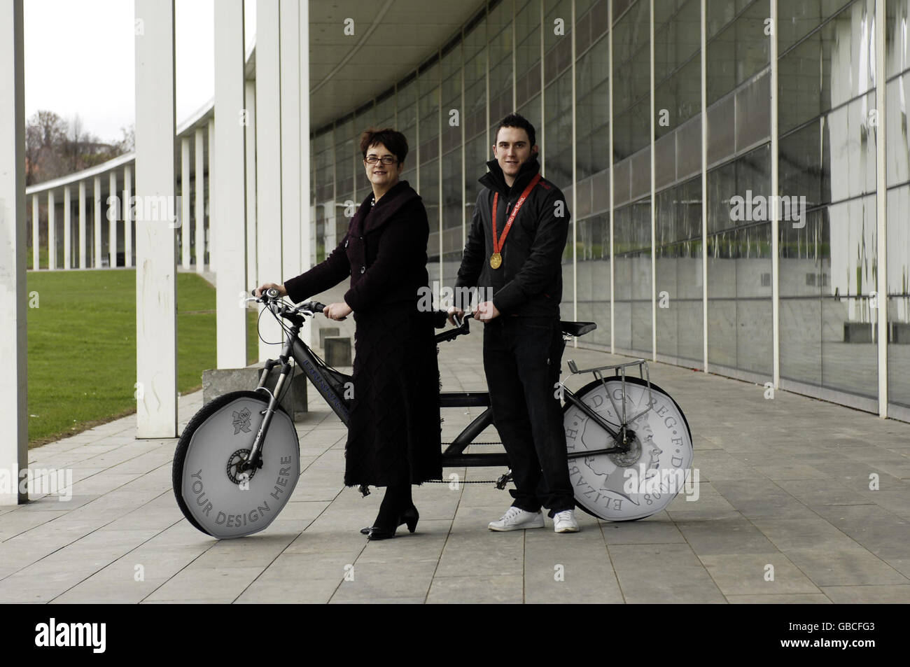 Sarah McCarthy-Fry, Sottosegretario di Stato per le Scuole e gli studenti, e Geraint Thomas, Medalista d'oro olimpico presso la Capital City Academy di Londra, posano con una bicicletta in tandem per contribuire a lanciare il Royal Mint London 2012 Design Competition per le Scuole secondarie. Foto Stock