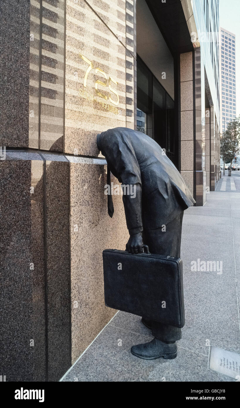 "Corporate testa' è una scultura in bronzo di Terry Allen di un più grande del vita uomo con la sua testa bloccata all'interno di un edificio per uffici nel centro di Los Angeles, California, USA. La statua di poke divertimento presso la lavorazione di atteggiamenti e di pressioni che faccia i dirigenti e i dipendenti che lavorano per aziende di grandi dimensioni. Una placca di metallo sul marciapiede dietro l'uomo ha questa citazione da Phillip Levine: "Hanno detto che avevo una testa per il business. Mi hanno detto di andare avanti ho dovuto perdere la mia testa. Hanno detto di essere concreti mi è diventato concreto. Hanno detto di andare, mio figlio, moltiplicare, dividere, conquista. Ho fatto del mio meglio". Foto Stock