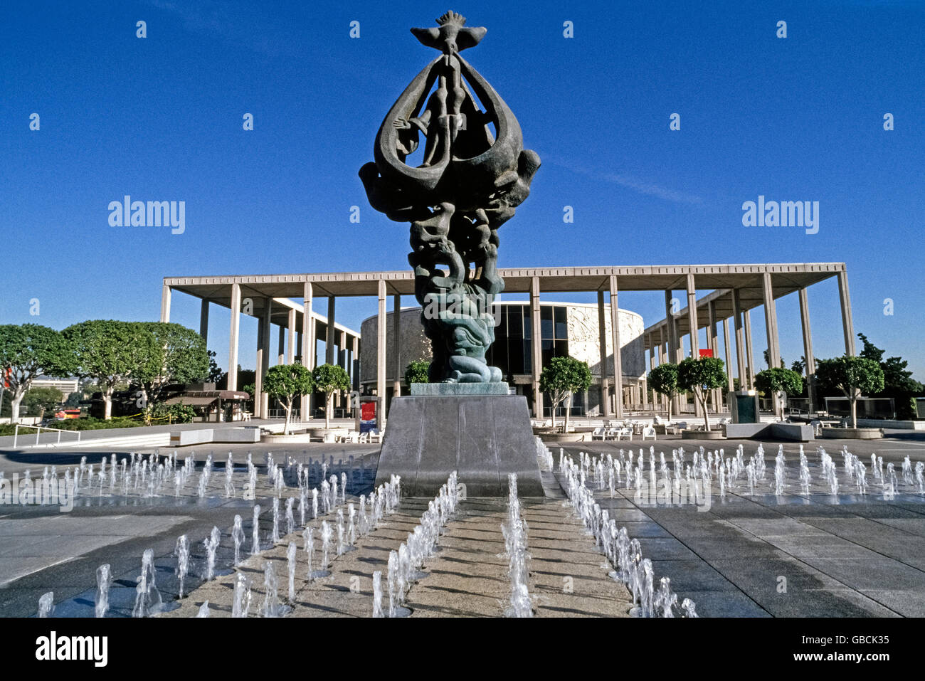L'imponente "Pace sulla terra" scultura in bronzo di Jacques Lipchitz sorge in mezzo 280 fontane danzanti nel Music Center Plaza nel centro di Los Angeles, California, USA. Salendo a 29 piedi (8,8 metri), la 10-ton (10000-chilogrammo) artwork è stato dedicato nel 1969 ed è sormontato da una colomba che scende sulla terra con lo spirito di pace. Questa è la più grande scultura creati dalla Lithuanian-born artist, morto nel 1973. Edificio rotondo dietro di esso è il marchio Taper Forum, uno dei diversi luoghi della Performing Arts Center di Los Angeles County, che è meglio conosciuto come la Music Center. Foto Stock
