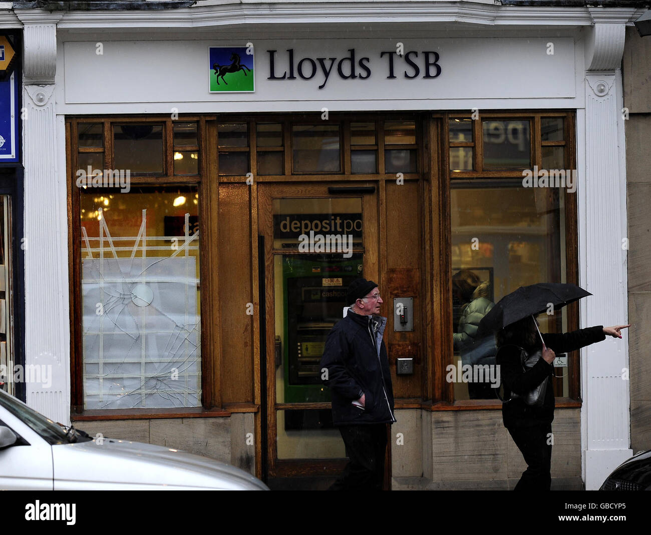 Una finestra rotta con nastro attende di essere riparata presso la filiale Lloyds TSB Bank di Ilkley, non è noto come o perché la finestra è stata rotta. Foto Stock