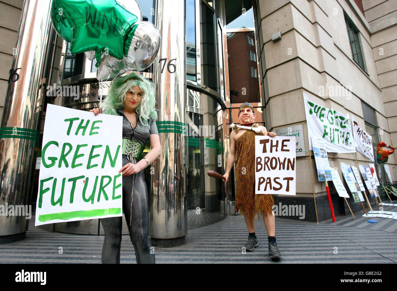 Gli attivisti ambientalisti che ritraggono la protesta "il futuro verde contro il passato marrone" al di fuori del Dipartimento dei trasporti di Westminster, nel centro di Londra, puntando verso un futuro verde e lasciando il "passato marrone" ben indietro. Foto Stock