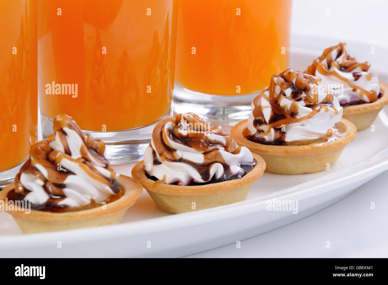 Frollini сakes inceppamento riempiti con panna e cioccolato topping caramel Foto Stock