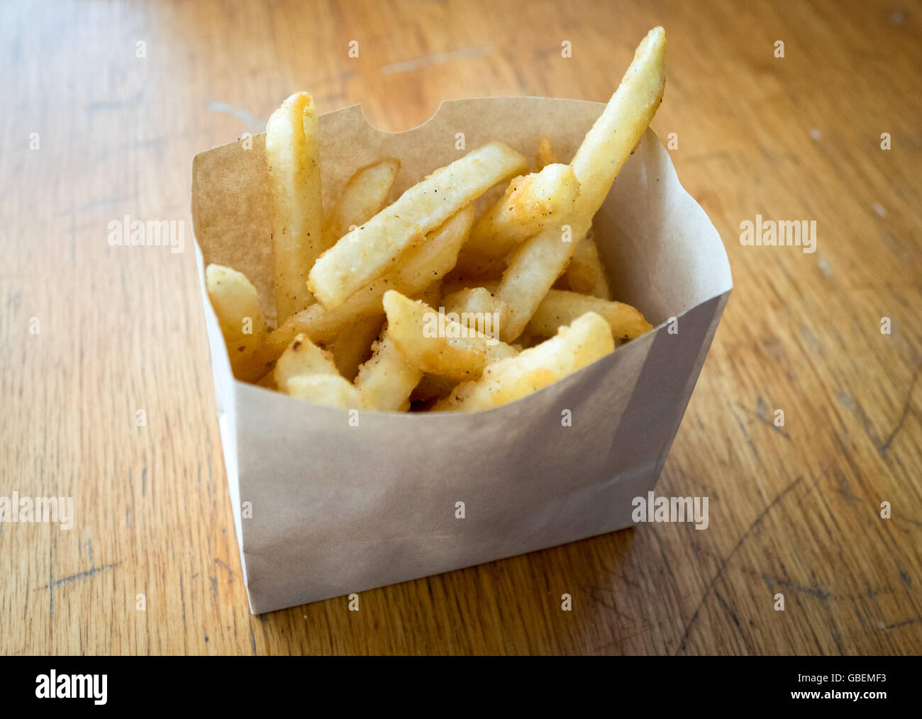 Le patatine fritte in un foglio di carta cartone. Foto Stock