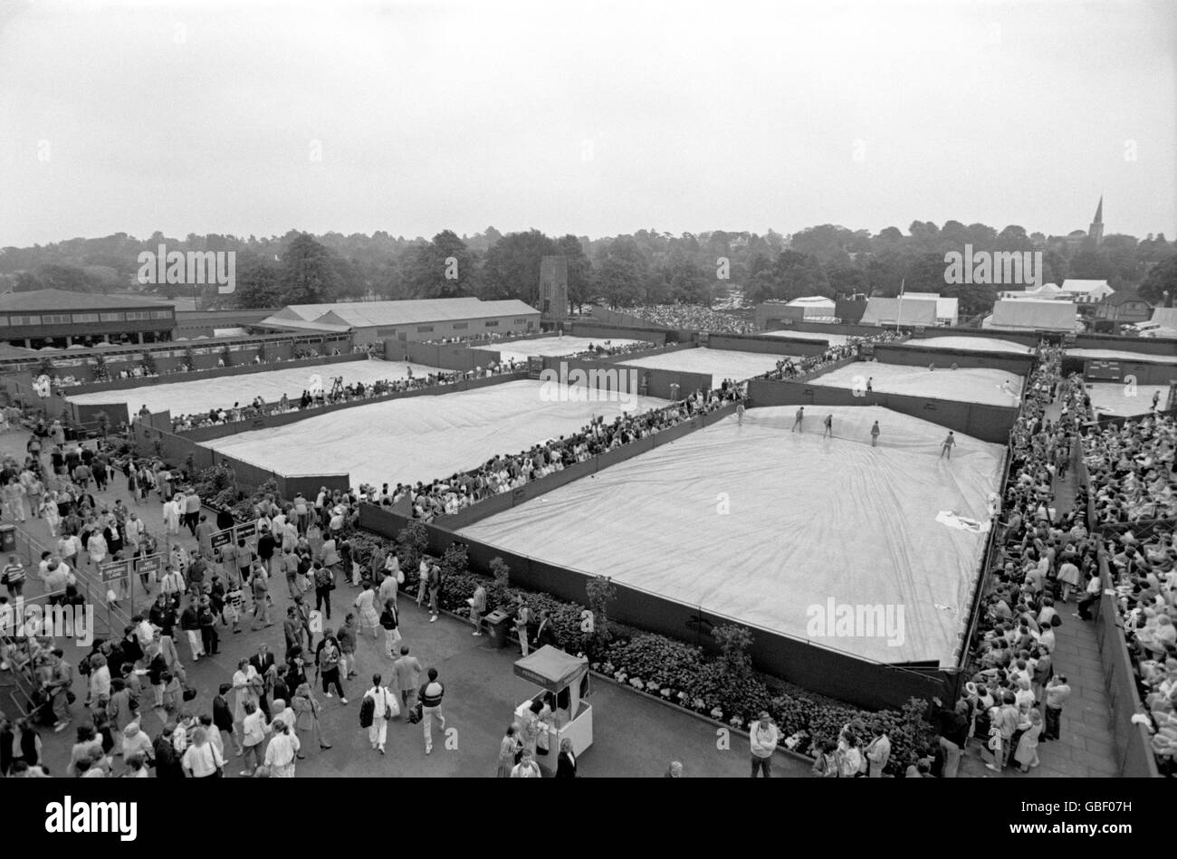Una vista familiare a Wimbledon come i tribunali esterni sono coperto contro la pioggia Foto Stock