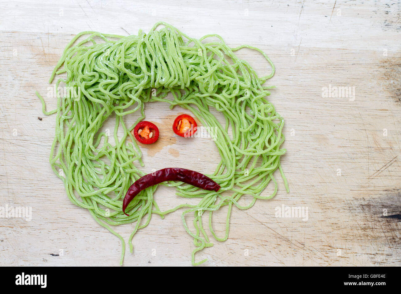 Facce tristi su legno sfondo costituito da grassi vegetali e a base di noodle Foto Stock