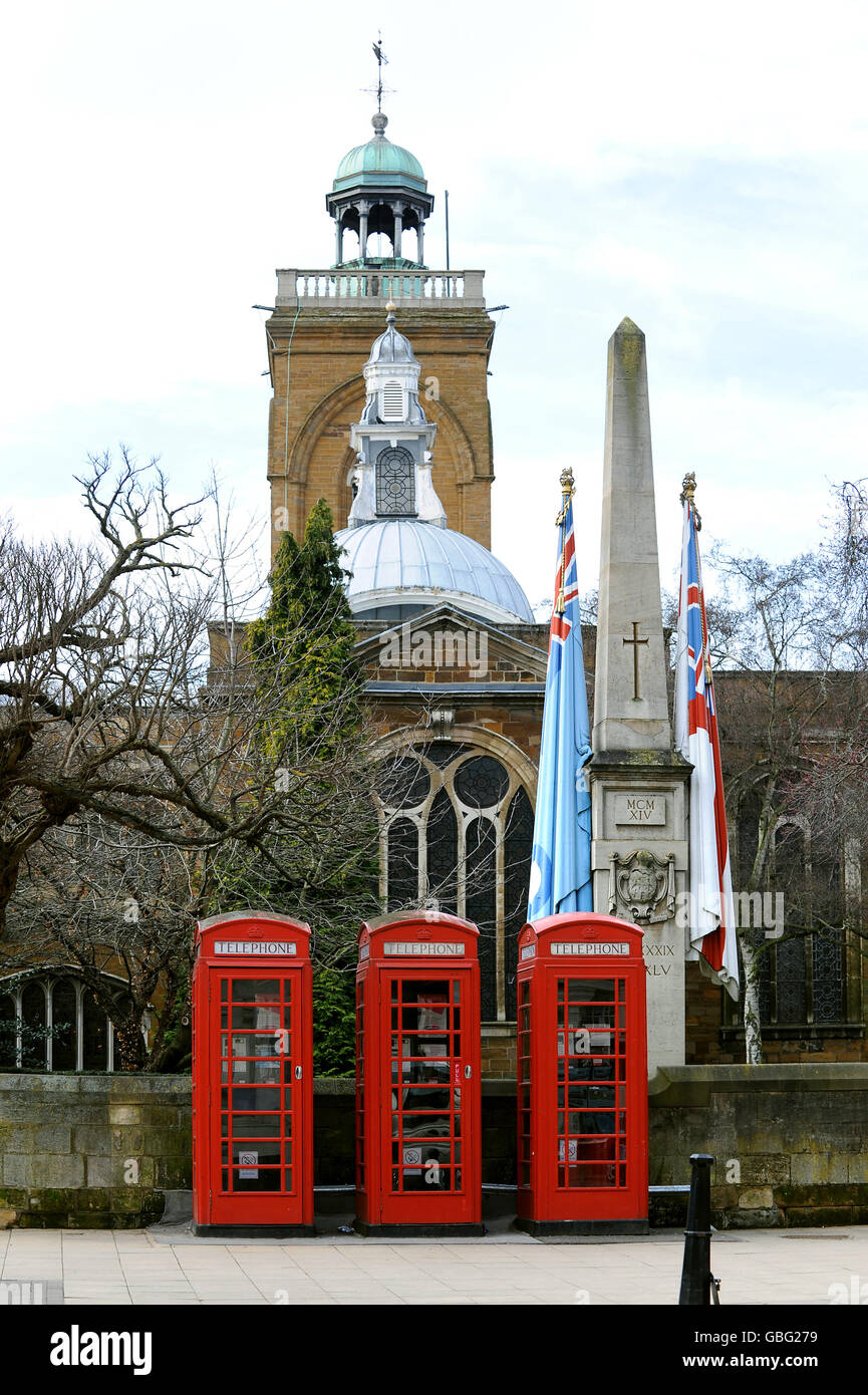 Tre caselle telefoniche rosse su Wood Hill, Northampton con la Chiesa di tutti i Santi sullo sfondo Foto Stock