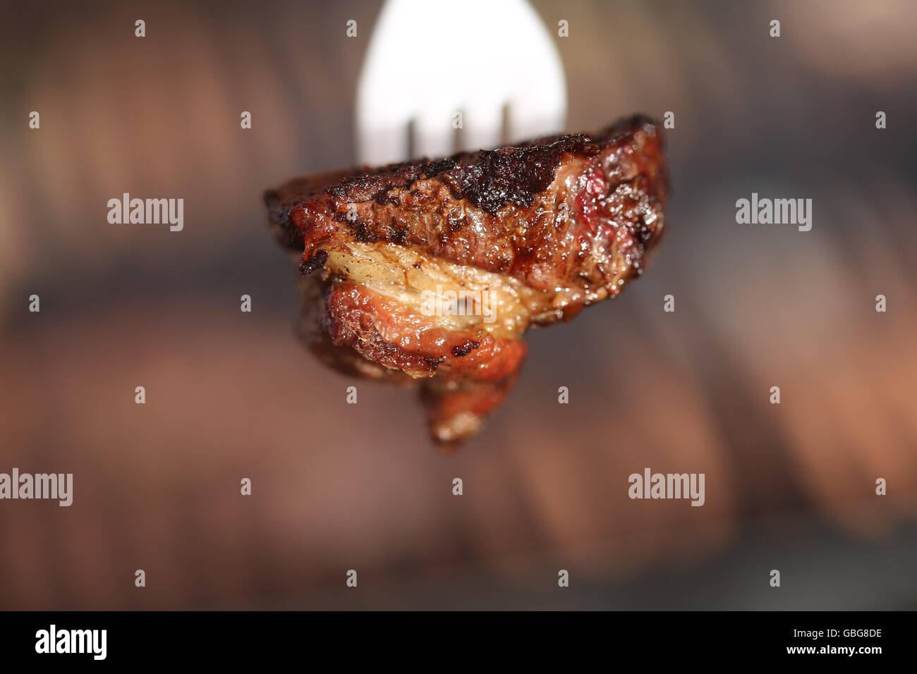 Pezzo di rara di carni bovine su una forcella di plastica. Pezzo di sinta bistecca su una forcella monouso, vicino. La carne rossa bloccato su un bianco forcella di plastica. Bon appetit! Foto Stock