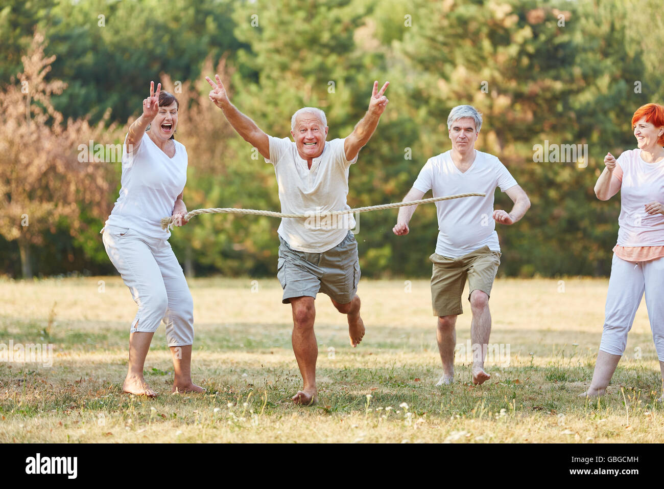 Happy seniors vincendo la gara di corsa nel parco Foto Stock
