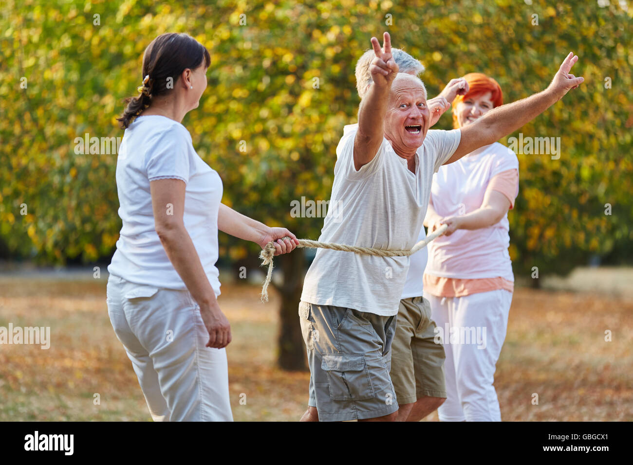 Active seniors felici di vincere la gara nel parco Foto Stock