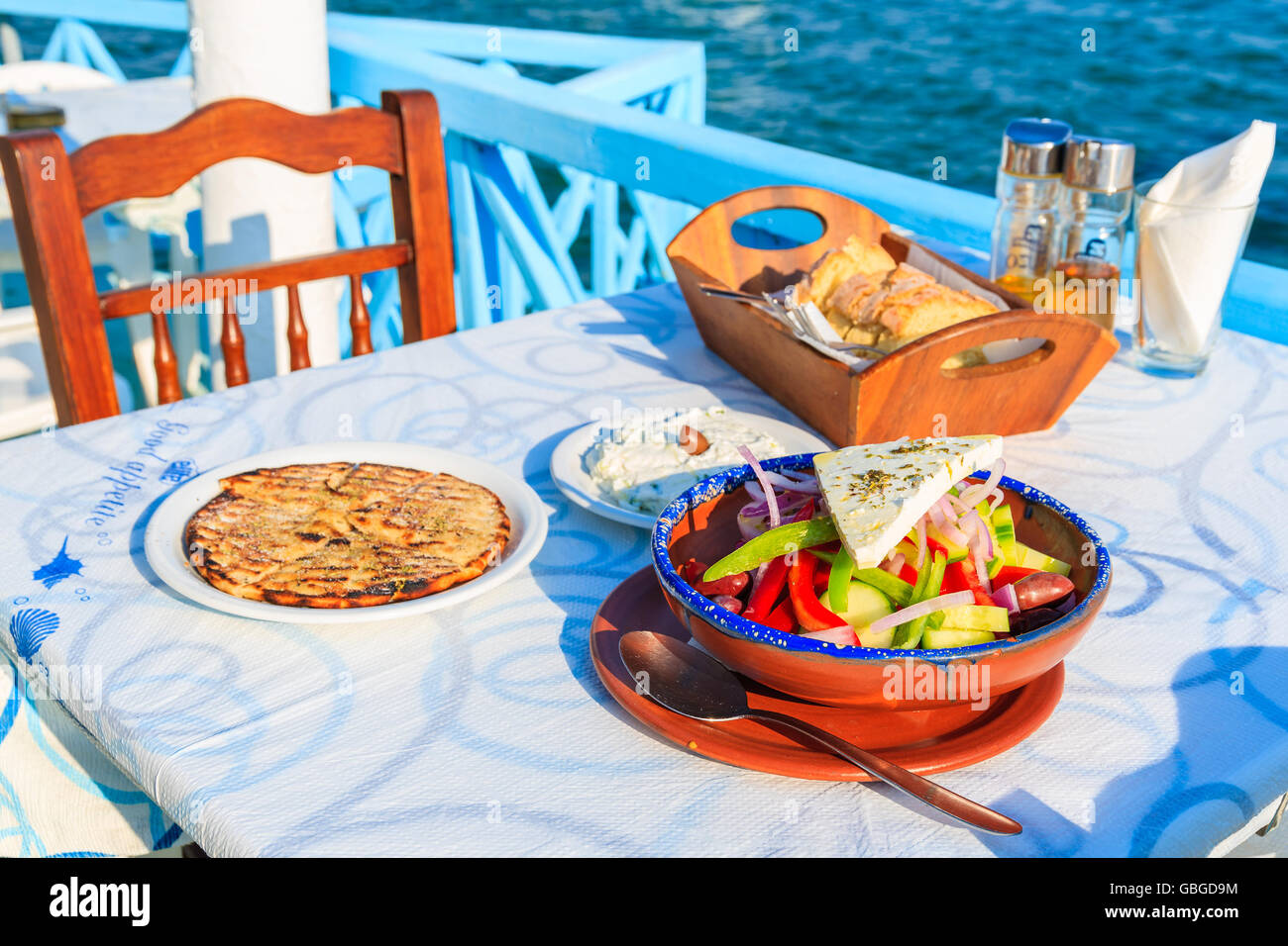 Isola di Samos, Grecia - Sep 20, 2015: insalata greca sulla tavola in taverna tradizionale con il mare blu acqua in background su Samos islan Foto Stock