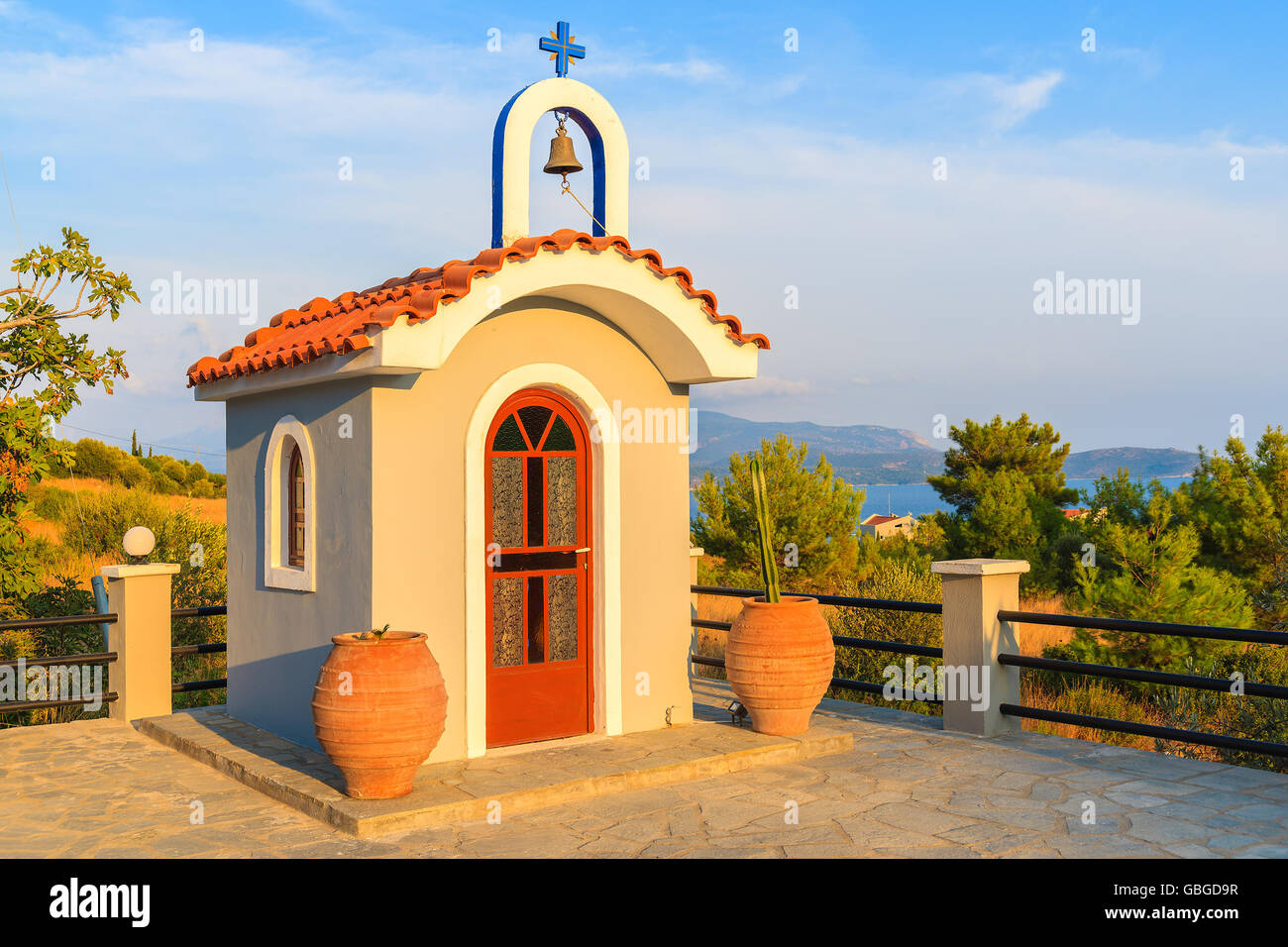 Piccola cappella Greca sulla costa di Isola di Samos nella calda luce del tramonto, Grecia Foto Stock