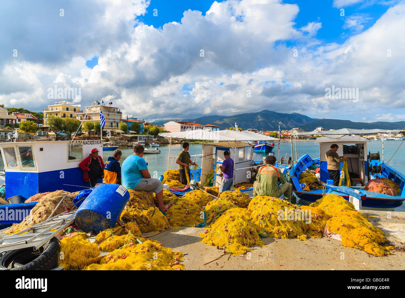 Isola di Samos, Grecia - Sep 23, 2015: pescatore riparare reti nella porta sul pomeriggio soleggiato. Le isole greche sono famosi per la tradizione Foto Stock