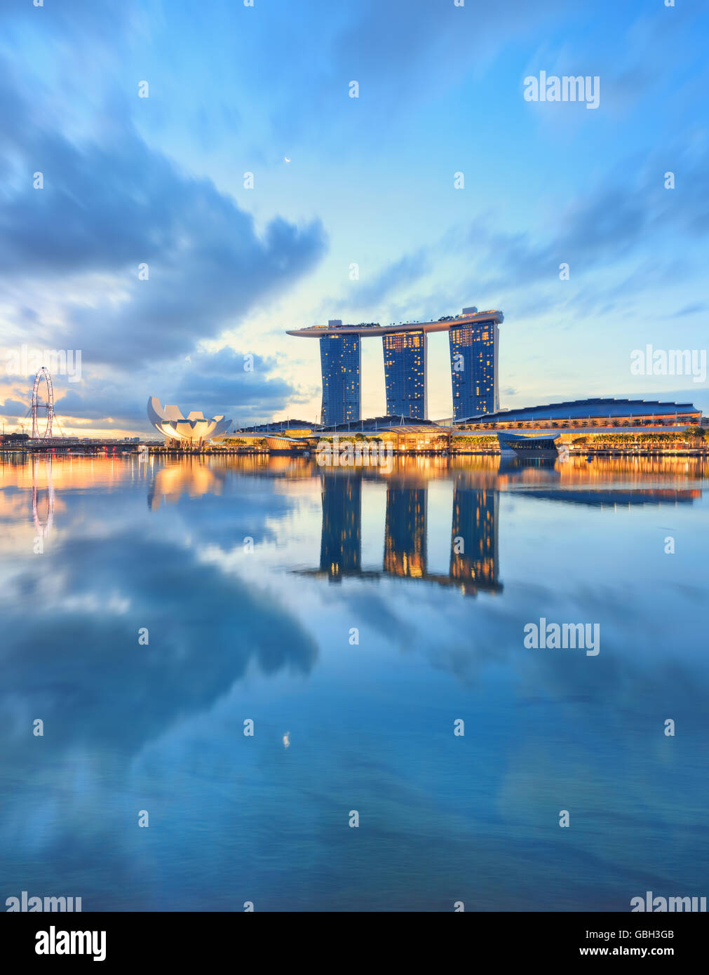 Vista su Singapore Marina Bay con acqua sul primo piano. Città moderna architettura presso sunrise Foto Stock