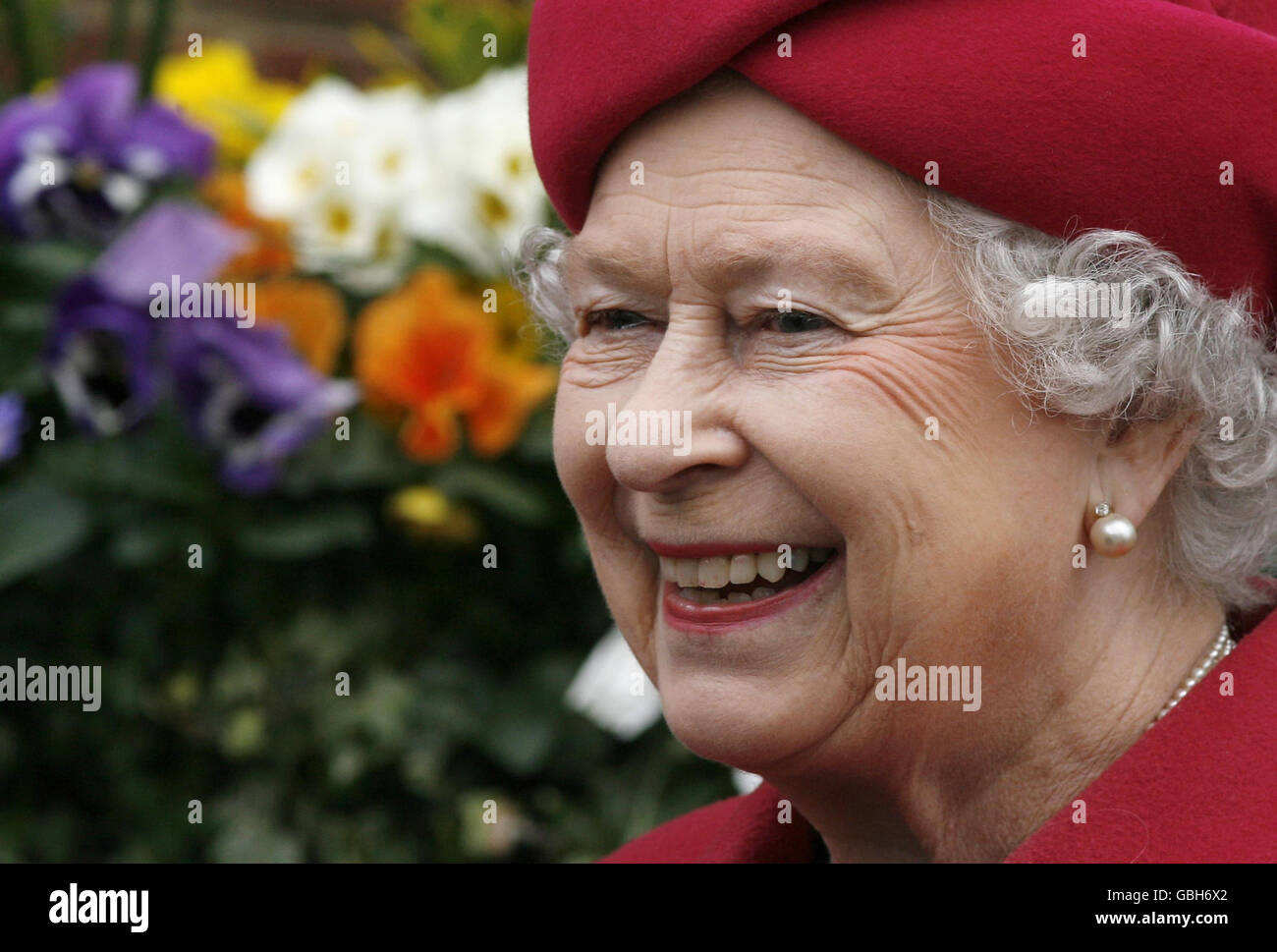 La regina Elisabetta II sorride durante una visita allo stabilimento di imbottigliamento della società di bevande Britvic nella parte orientale di Londra. Foto Stock