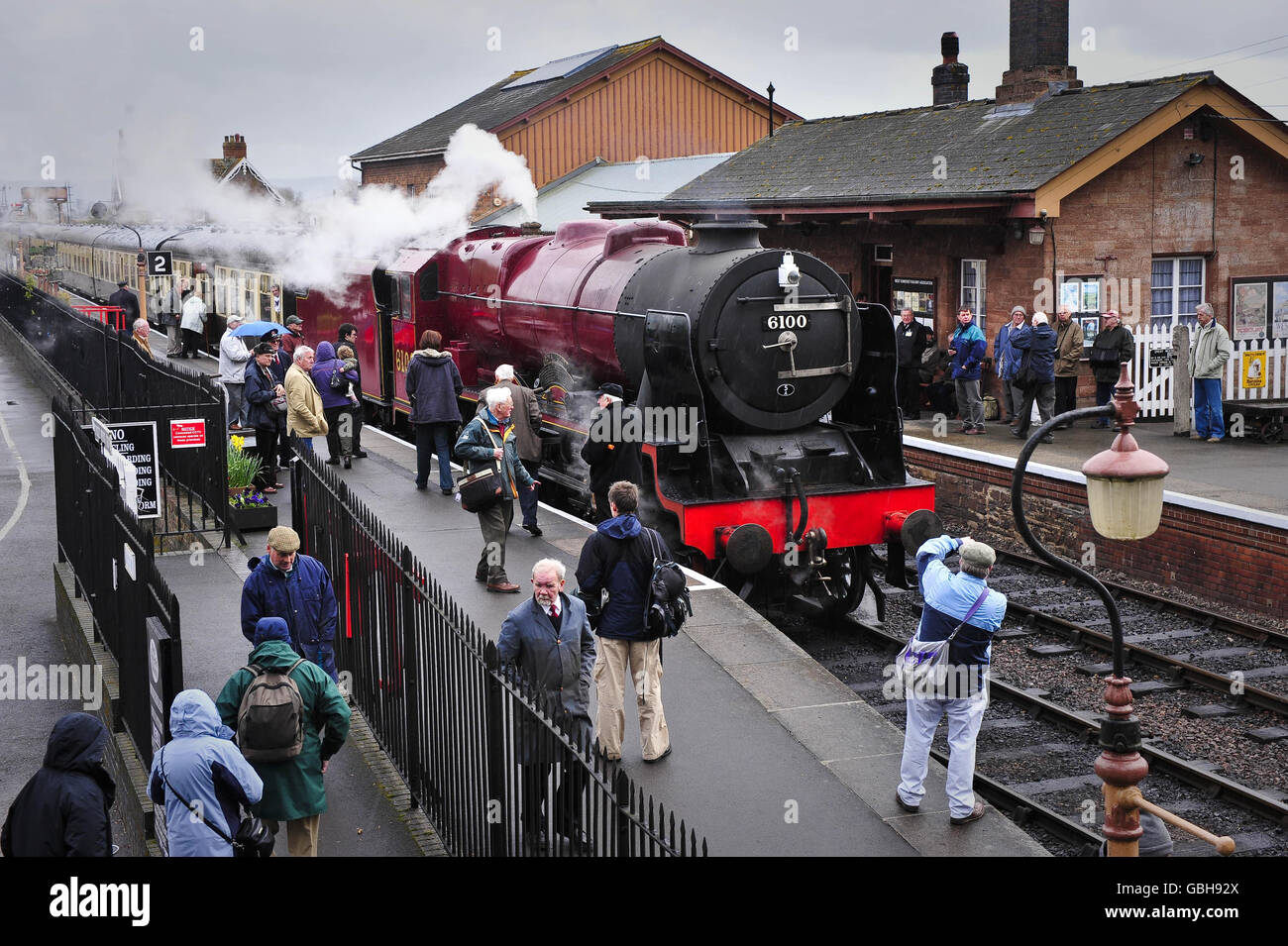 Gli appassionati della ferrovia si riuniscono per scattare foto e ammirare il motore a vapore Royal Scot LMS 6100, recentemente restaurato, alla stazione Bishop di Lydeard il primo giorno di quattro giorni, partecipando al galà a vapore primaverile della West Somerset Railway. Foto Stock