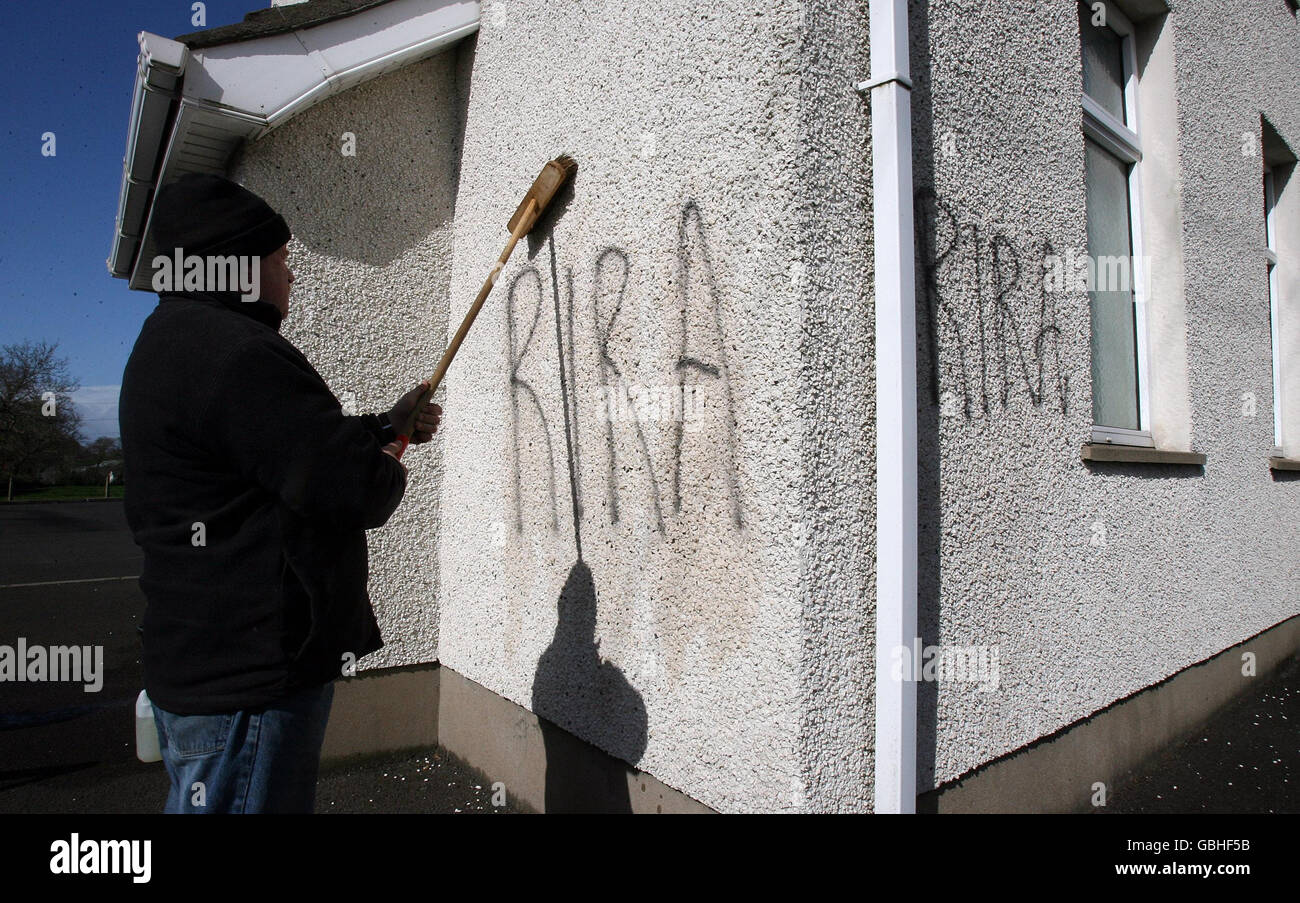 Gli operai rimuovono i graffiti repubblicani dalla Knocknadona Hall, sulla Glenavy Road fuori Lisburn, Co Antrim. Foto Stock