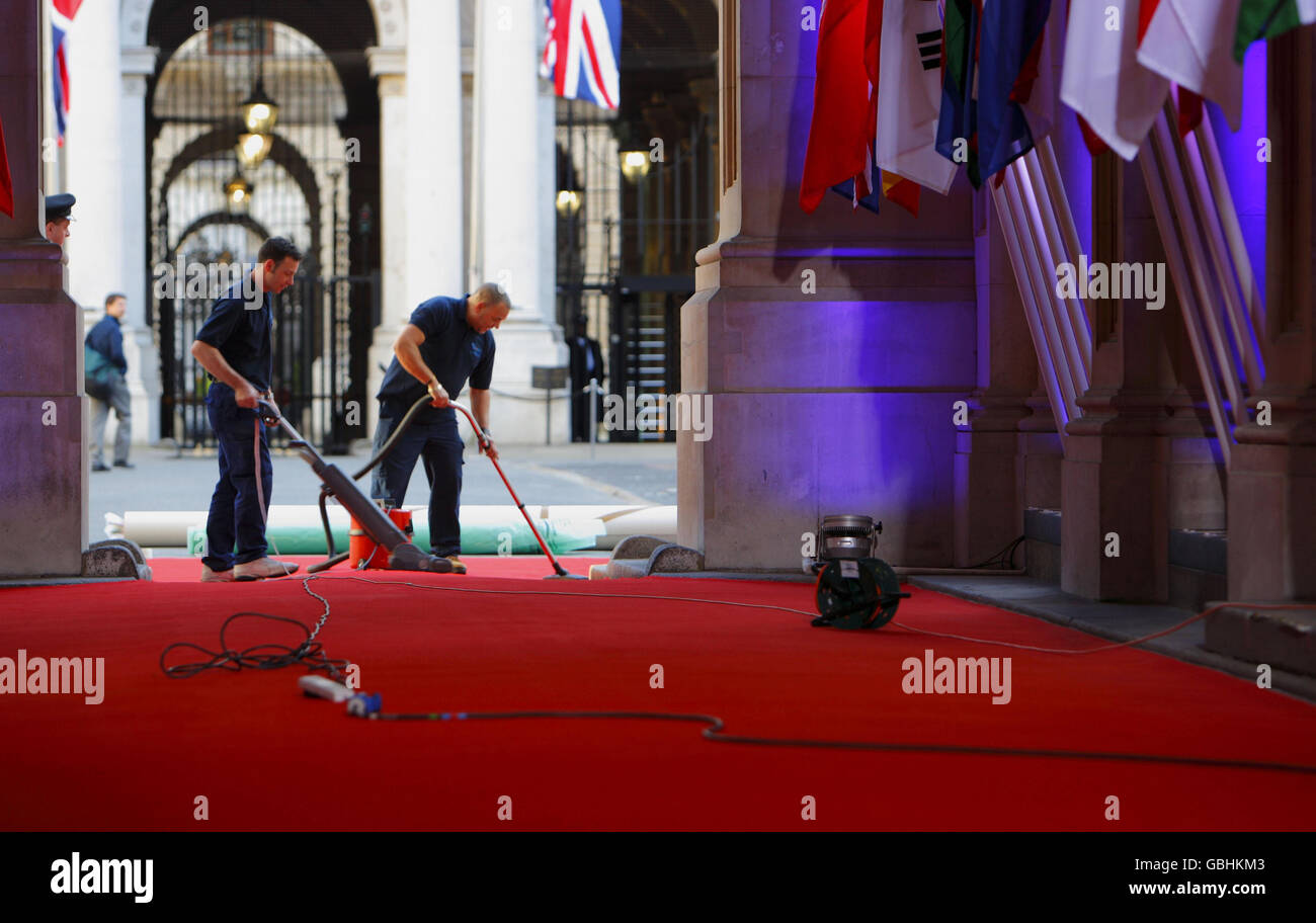 Il personale prepara il tappeto rosso prima che gli ospiti arrivino al 10 di Downing Street per partecipare a una cena prima del vertice del G20. Foto Stock