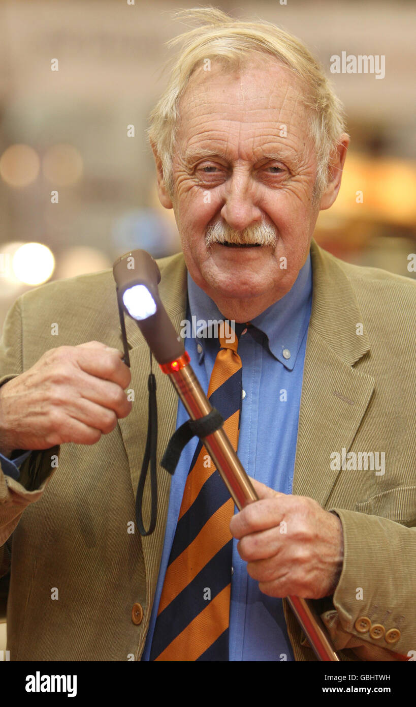 L'inventore Trevor Baylis dimostra la sua nuova invenzione, la 'Slik-Stik', al EDF Ideal Home Show di Earls Court, Londra. Il trovato è un bastone che presenta un allarme luminoso e acustico alimentato da un'orologeria, che l'utente carica avvolgendo una maniglia. Foto Stock