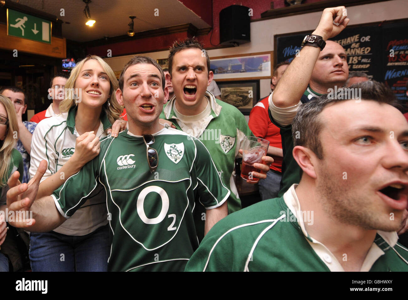 I tifosi irlandesi di rugby incoraggiano la loro squadra contro il Galles nella partita finale della RBS 6 Nations tra il Galles e l'Irlanda nel pub Borough Arms vicino al Millennium Stadium di Cardiff. Foto Stock