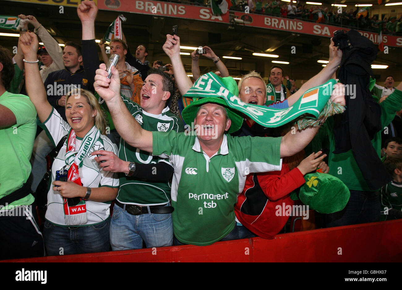 I fan irlandesi celebrano il Grand Slam durante la partita RBS Six Nations al Millennium Stadium di Cardiff, Galles. Foto Stock