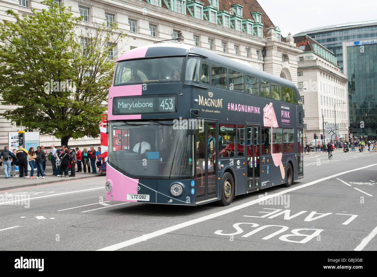 A Londra i nuovi autobus Routemaster a Marylebone con rosa e nero Magnum unità pubblicitaria sul Westminster Bridge London, Regno Unito Foto Stock