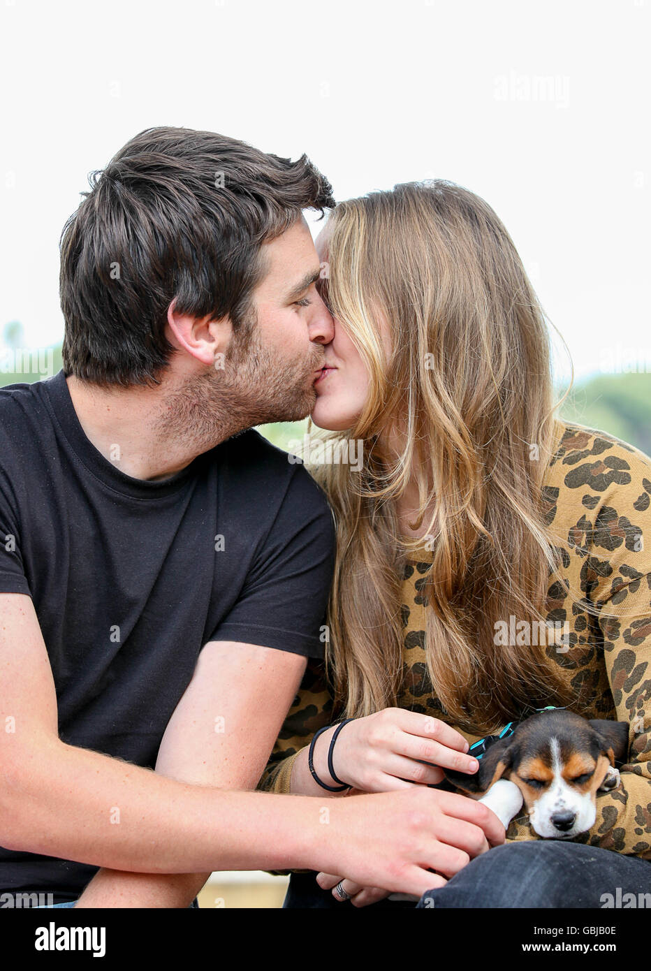 Felice coppia baciare con cane Foto Stock