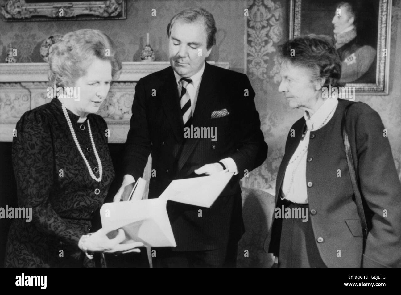 Il primo ministro Margaret Thatcher riceve oggi le azioni di Capo Cornovaglia per conto del National Trust, dal dottor Tony o'Reilly, presidente della Heinz Food Company, al 10 di Downing Street. Guardando sopra è Dame Jennifer Jenkins, presidente del National Trust e moglie del deputato Roy Jenkins. Foto Stock
