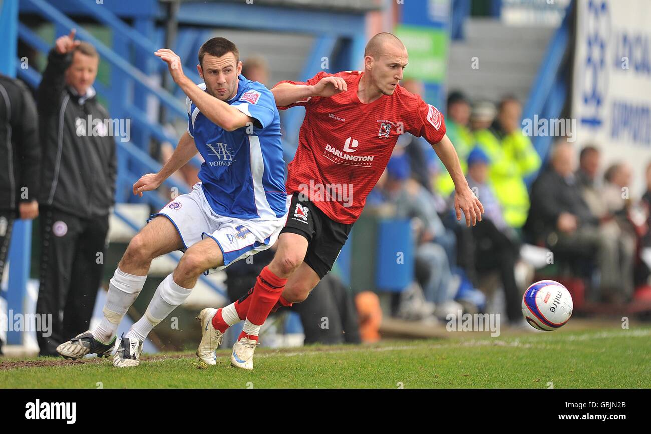 David Poole di Darlington (a destra) e Jamie Lowry di Chesterfield durante la partita della Coca-Cola Football League Two al Recreation Ground di Chesterfield. Foto Stock