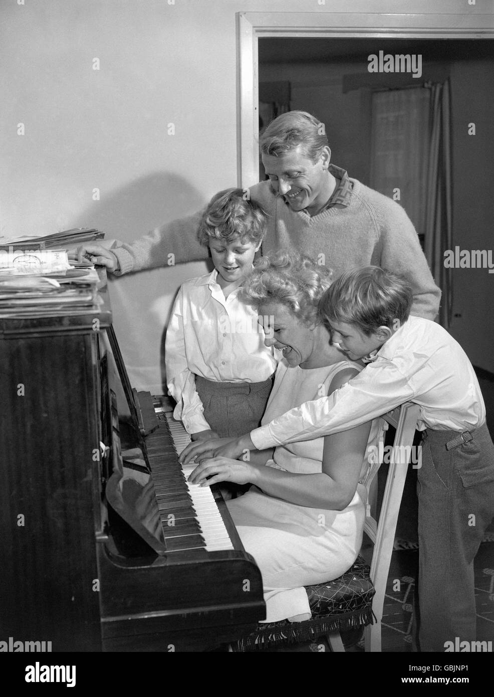 La star della registrazione Gary Miller con la sua famiglia al pianoforte durante una prova nella sua casa londinese per la sua stagione estiva, che si apre al Lido, Margate, Kent. La moglie di Gary, la gioia, suona il pianoforte e ha l'aiuto dei loro figli, Jonathan (Jonty), 9 anni, a sinistra, e Christopher (Kit), 11 anni. Foto Stock