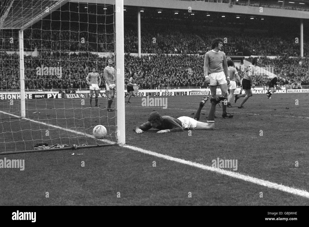 Keith MacRae (sul pavimento), portiere della città di Manchester, guarda con deiezione alla palla nella sua rete dopo che Wolverhampton Wanderers ha segnato il gol vincente Foto Stock