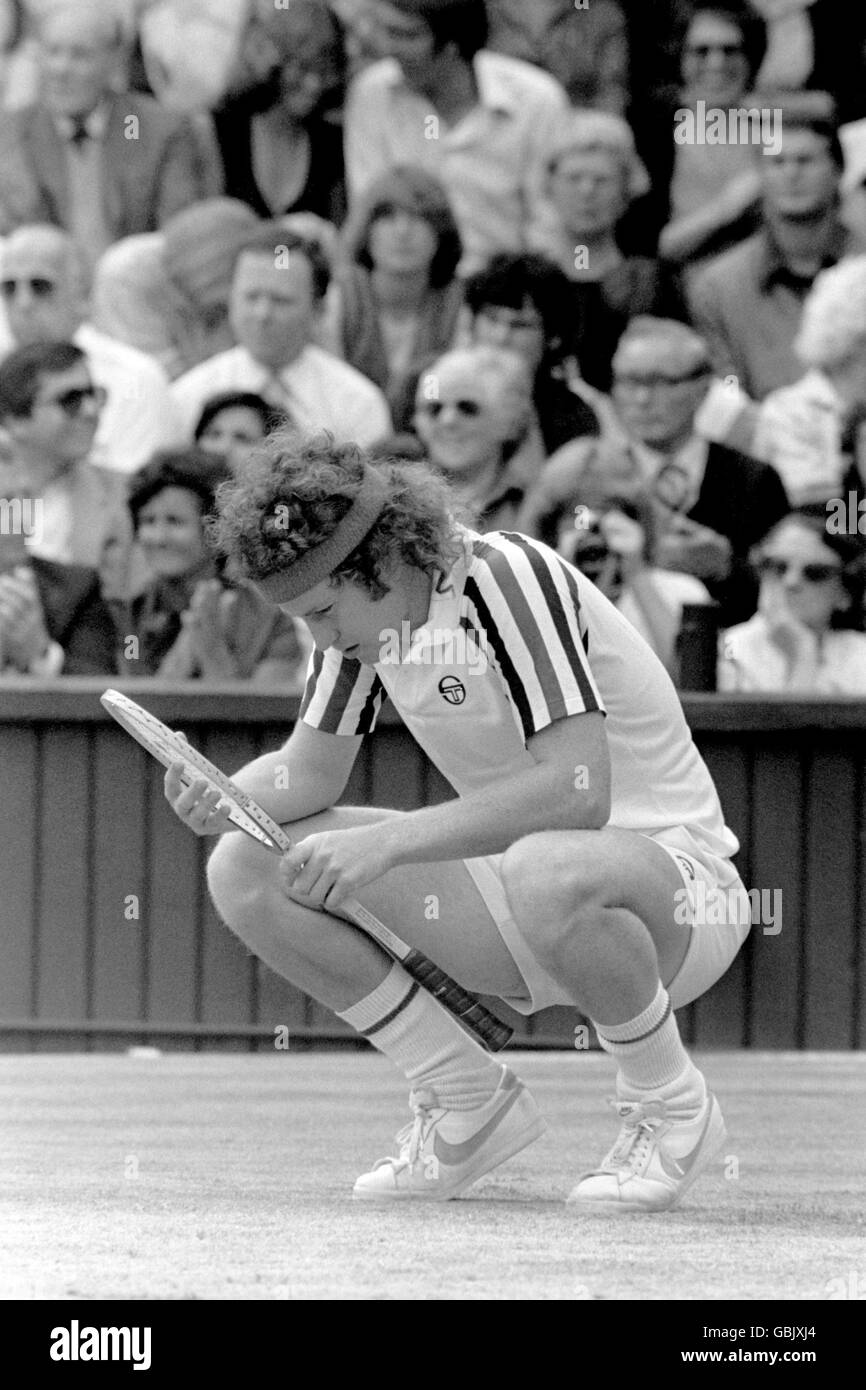 Tennis - Wimbledon Championships - Men's Singles - Final - Bjorn Borg v John McEnroe. John McEnroe esamina la sua racchetta dopo aver giocato un colpo povero Foto Stock
